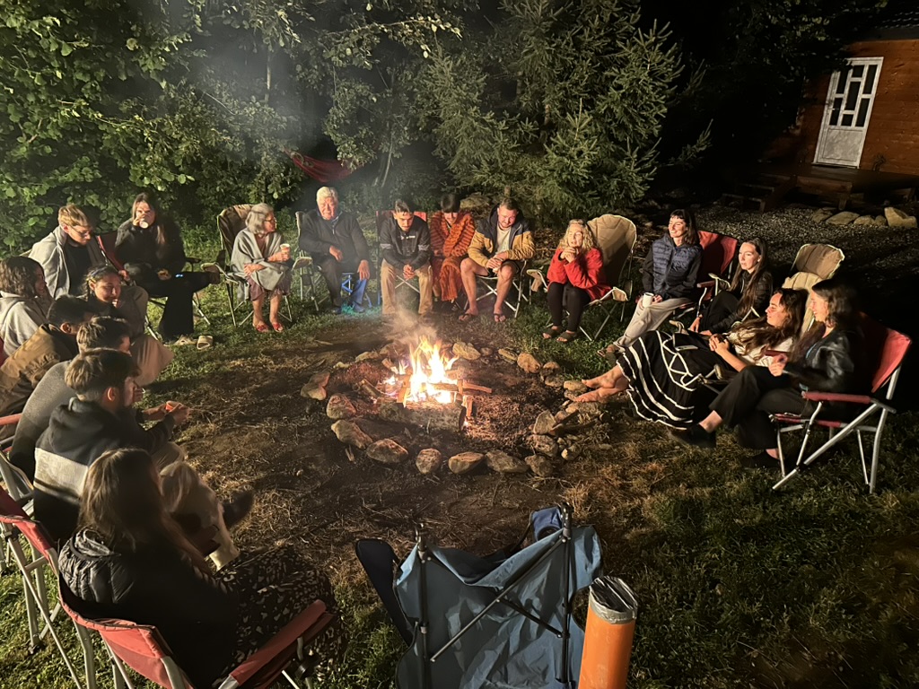 Friends gathered around a bonfire at night.