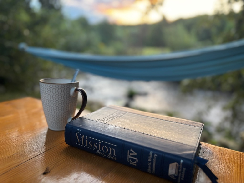 A Bible on an outdoor table in the evening light.